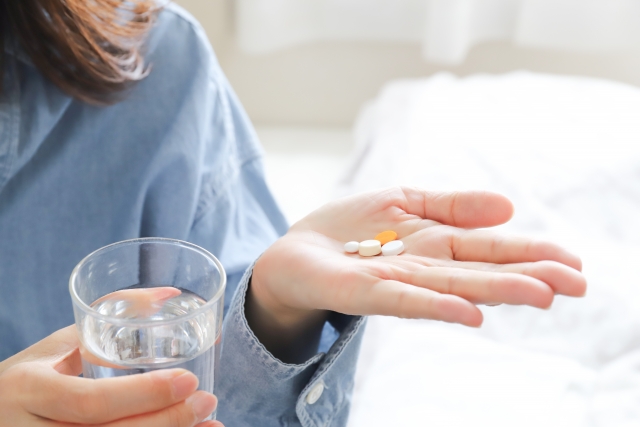 処方薬を飲む女性